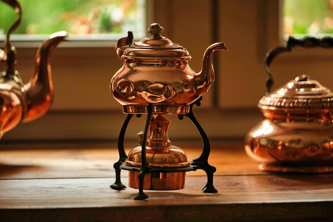 Koperen lamp naast houten bijzettafel.