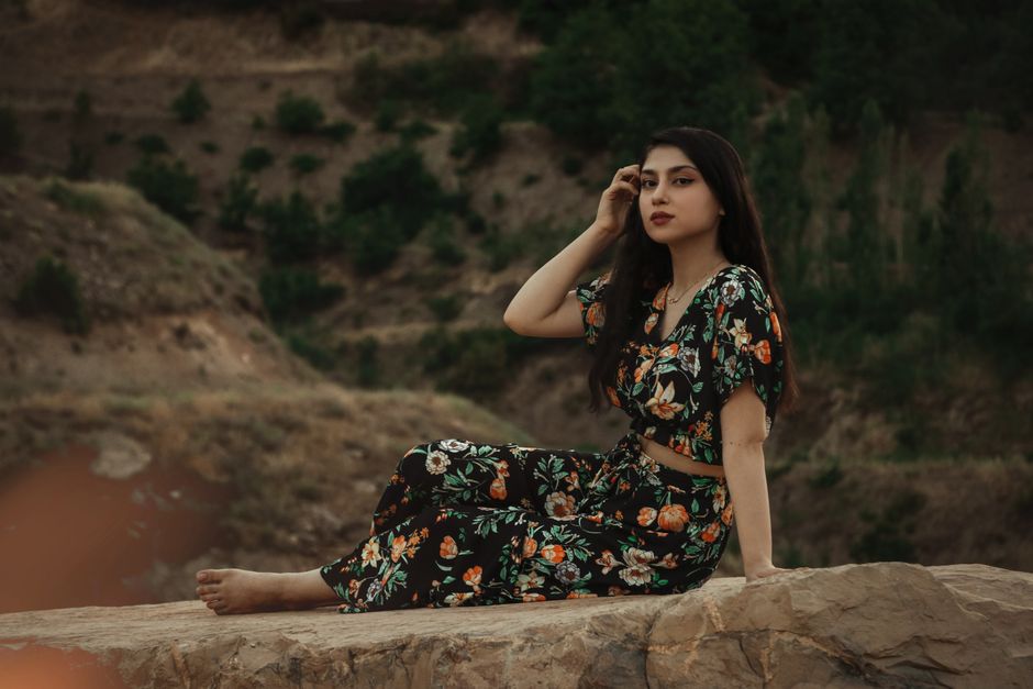 Vrouw combineert bloemrijke blouse met broek.