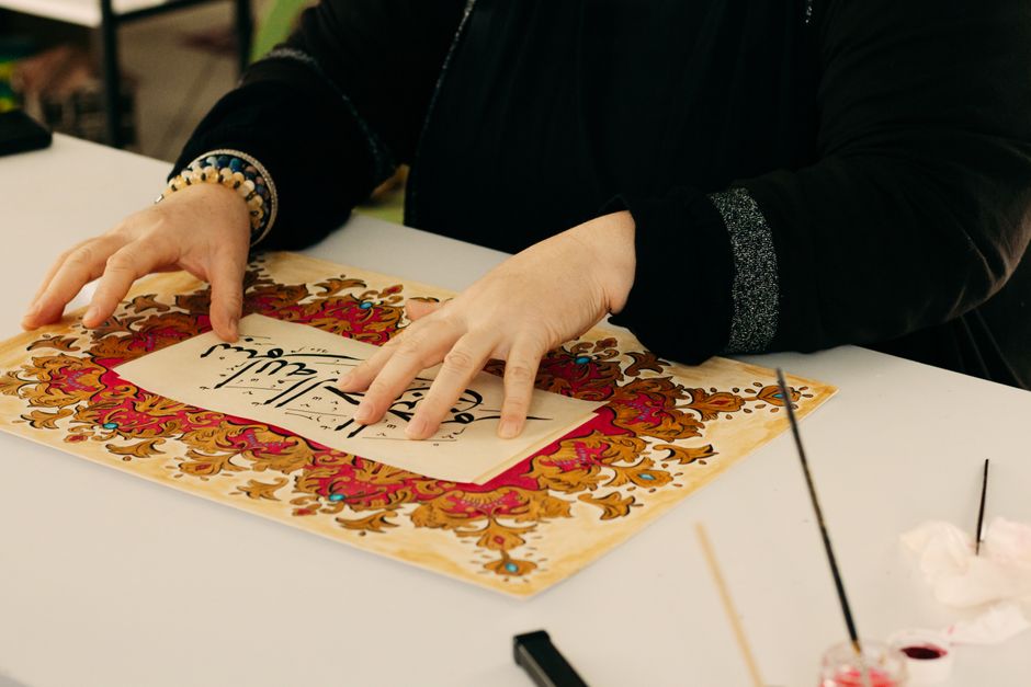 Mensen bladeren door tweedehands kunst bij een markt.