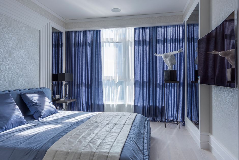 Blauwe gordijnen met rustgevende tinten in slaapkamer. Blauwe gordijnen met rustgevende tinten in slaapkamer.